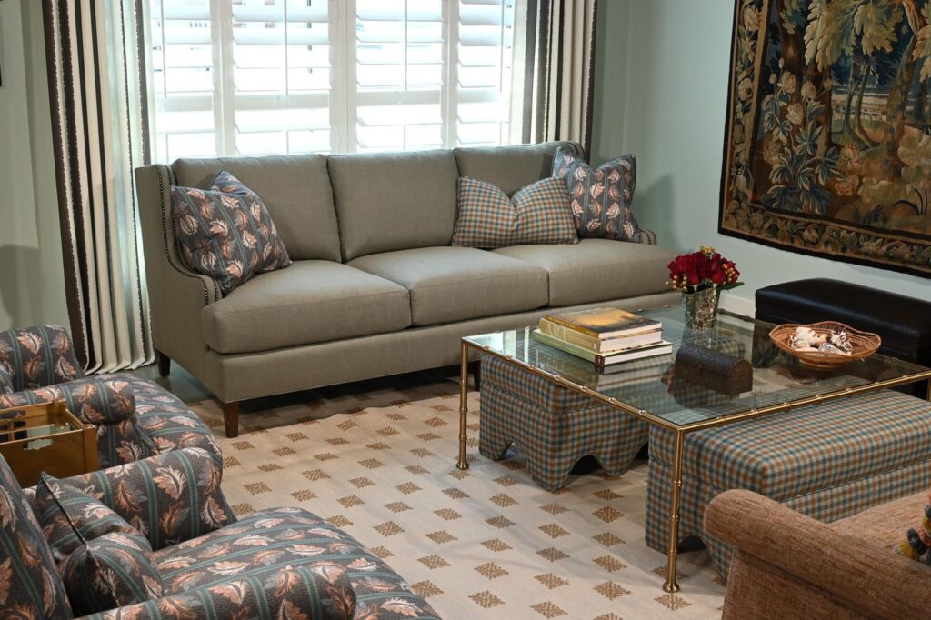 A living room with a sofa, coffee table, flower vase, and wall decorations, creating a welcoming and stylish space